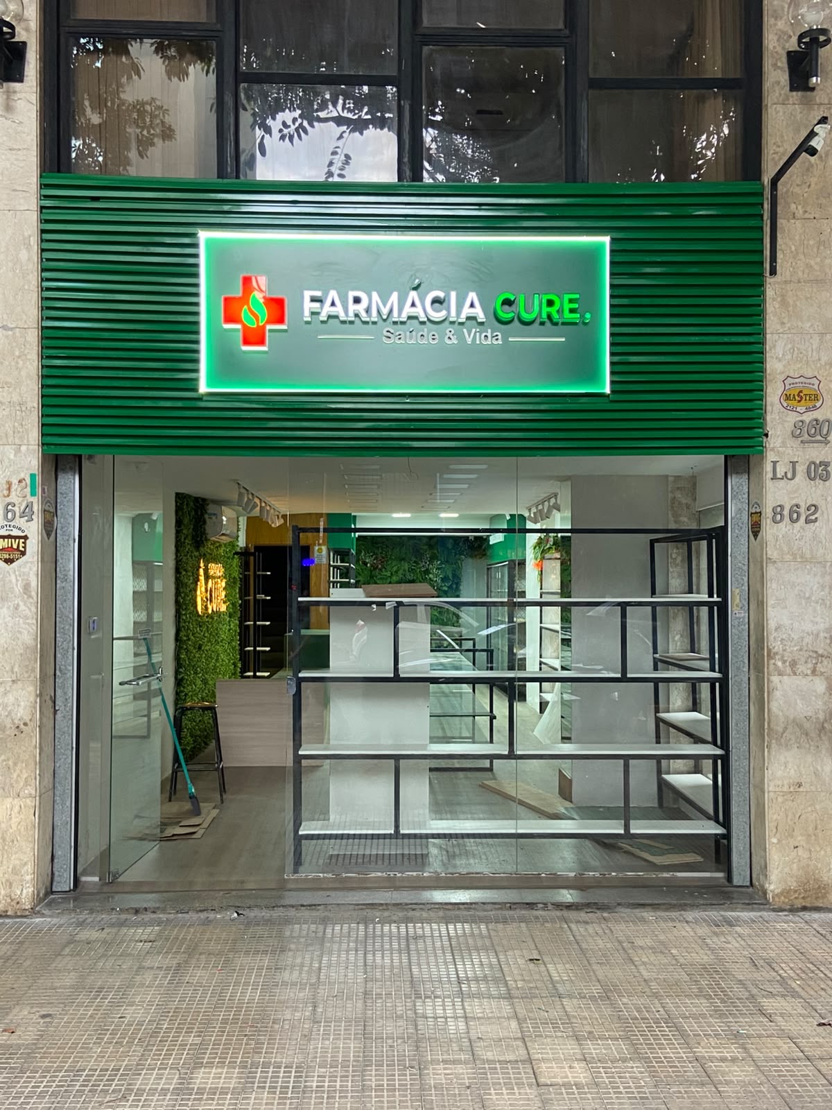 Letreiro Farmácia CURE – Saúde & Vida na fachada verde da unidade Savassi